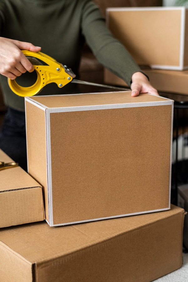 Man putting tape on a cardboard box